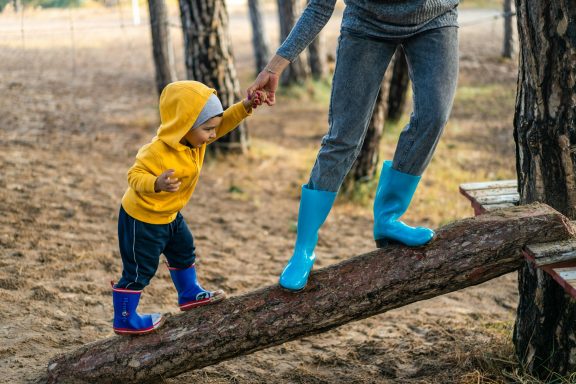 Child and nanny on a log